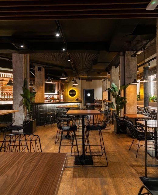 Ogham Event Venue Barcelona – spacious, modern industrial-style venue with warm lighting, perfect for corporate events.